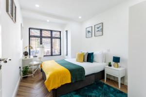a white bedroom with a bed and a window at Stunning West London W7 Modern Huge place 4bed 2 bath with garden free parking (7 occupancy) in London