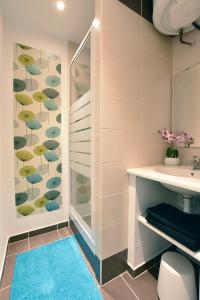 La salle de bains est pourvue d'une douche et d'un tapis bleu. dans l'établissement Studio Cosy centre historique et au calme (3), à Montpellier