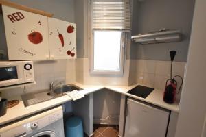 eine kleine Küche mit einer Spüle und einer Mikrowelle in der Unterkunft Studio Cosy centre historique et au calme (3) in Montpellier