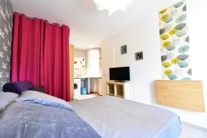 ein Schlafzimmer mit einem Bett und einem roten Vorhang in der Unterkunft Studio Cosy centre historique et au calme (3) in Montpellier