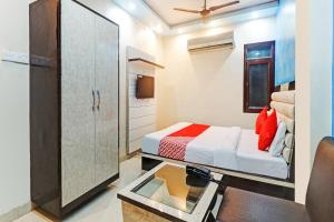 a small room with a bed and a mirror at Collection O Hotel Shree Narayan Regency in Kānpur