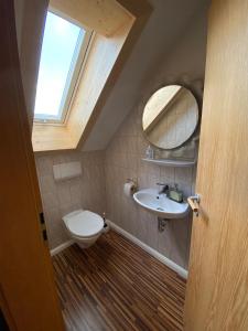 ein Badezimmer mit einem WC, einem Waschbecken und einem Spiegel in der Unterkunft VOLLMER home in Titisee-Neustadt
