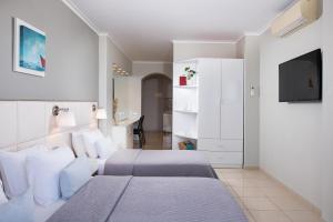 a bedroom with two beds and a flat screen tv at Olympic Star Beach Hotel in Nei Poroi