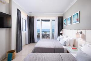 a hotel room with two beds and a view of the ocean at Olympic Star Beach Hotel in Nei Poroi