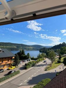 einen Balkon mit Blick auf eine Straße und einen See in der Unterkunft VOLLMER home in Titisee-Neustadt