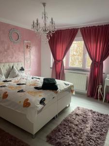a bedroom with a bed with pink curtains and a chandelier at Tamara’s Place in Râmnicu Vâlcea