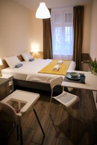 a hotel room with a bed and a table and chairs at East Station Comfort Plus in Budapest