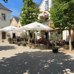 un patio con mesas, sillas y sombrillas en Eifelstube Ahrweiler, en Bad Neuenahr-Ahrweiler