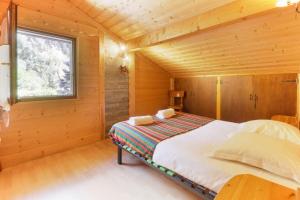 里雾诗Chalet YOLO, Vallée de Chamonix - sauna et jaccuzi的木屋里有一张床的卧室