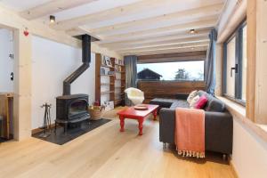 a living room with a couch and a fireplace at Chalet L'Oratoire - Huge Garden - Renovated Historic Chalet with Mountain Views in Les Houches