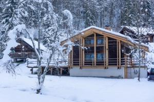 een blokhut in de sneeuw met sneeuw bedekte bomen bij Chalet L'Oratoire & Mazot - Renovated Historic Chalet - Huge Garden & Separate Cabin for 2 in Les Houches