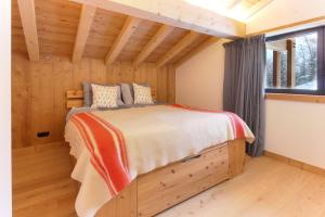 een slaapkamer in een blokhut met een bed bij Chalet L'Oratoire & Mazot - Renovated Historic Chalet - Huge Garden & Separate Cabin for 2 in Les Houches