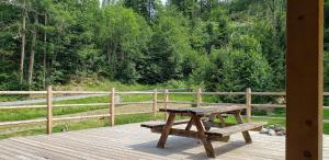 een houten picknicktafel op een houten terras bij Chalet L'Oratoire & Mazot - Renovated Historic Chalet - Huge Garden & Separate Cabin for 2 in Les Houches