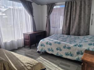 - une chambre avec 2 lits, une table et des fenêtres dans l'établissement Casa Campestre Sua Meca Guatavita, à Guatavita