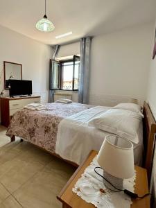 una camera con letto e tavolo con lampada di Casa Sissy a Lamezia Terme