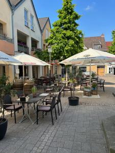 un patio al aire libre con mesas, sillas y sombrillas en Eifelstube Ahrweiler, en Bad Neuenahr-Ahrweiler