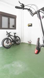 dos bicicletas estacionadas en una habitación con suelo verde en Apartamentos Turísticos Real Valle Ezcaray, en Zorraquín