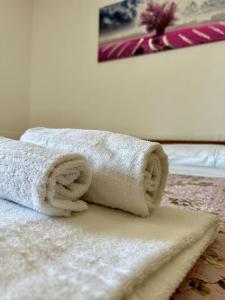 una pila di asciugamani poggiata sopra un letto di Casa Sissy a Lamezia Terme