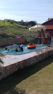 due persone in una piscina in un cortile di CHÁCARA KAUANNY SOCORRO SP a Socorro