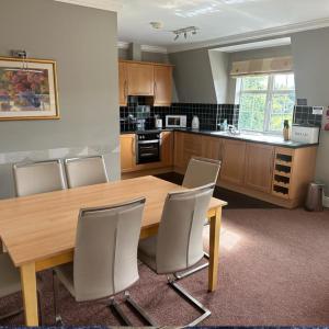 uma cozinha com uma mesa de jantar em madeira e cadeiras em Spacious 2 bedroom apartment in Killarney em Killarney