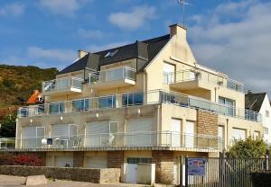an apartment building with a balcony and a roof at Glaz-Zen - Spacieux appt face à la mer in Erquy