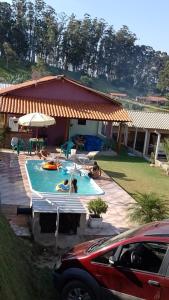 a car parked in front of a house with a swimming pool at CHÁCARA KAUANNY SOCORRO SP in Socorro