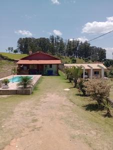 una casa con piscina frente a ella en CHÁCARA KAUANNY SOCORRO SP en Socorro