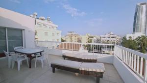 balcón con mesa, sillas y vistas a la ciudad en STAY Naturaleza Penthouse, en Limassol