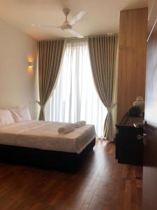 um quarto com uma cama e uma grande janela em Elevate Eden by PropertyBoutique em Colombo