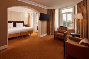une chambre d'hôtel avec un lit et une chaise dans l'établissement Van der Valk Palace Hotel Noordwijk, à Noordwijk aan Zee