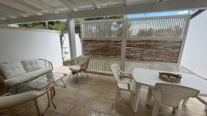 a patio with a table and chairs and a couch at Dimora Arnesano in Torre Lapillo