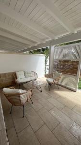 eine Terrasse mit 2 Stühlen und einer Bank auf einer Terrasse in der Unterkunft Dimora Arnesano in Torre Lapillo