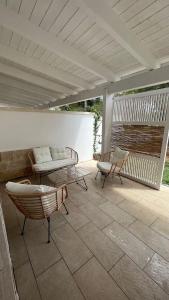 a patio with two chairs and a bench on a patio at Dimora Arnesano in Torre Lapillo