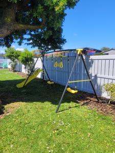 a playground with a slide in a yard at Aucktons house in Auckland