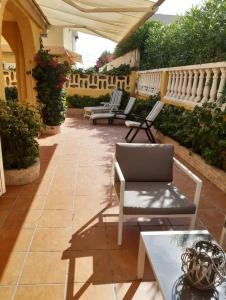 eine Terrasse mit zwei Stühlen und einem Tisch in der Unterkunft Adosado/casa con terraza y buhardilla. Playa El Perelló in El Perelló