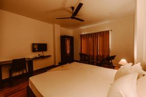 a bedroom with a bed and a table and chairs at Dibrugarh Tea Residency in Dibrugarh