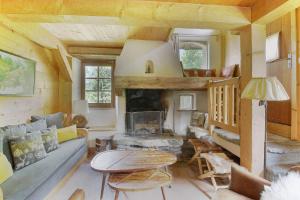 een woonkamer met een bank en een open haard bij Chalet de charme - 8 pers - 140m2 - Jardin - Calme in Les Houches