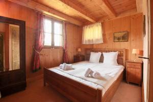 een slaapkamer met een bed met witte lakens en een raam bij Chalet de charme - 8 pers - 140m2 - Jardin - Calme in Les Houches