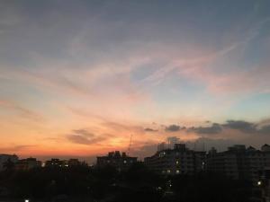 a city skyline with a sunset in the sky at The STYLISH Hometel Sukhumvit in Bangkok