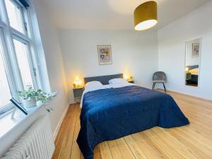 um quarto com uma cama com um edredão azul em aday - Sunset Suite em Randers