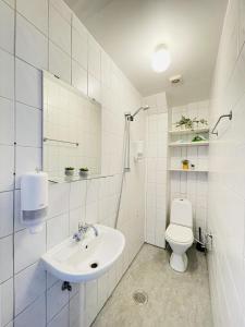 uma casa de banho branca com um lavatório e um WC em aday - Sunset Suite em Randers