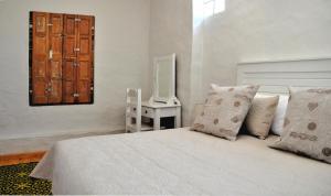 um quarto com uma cama e uma mesa com um espelho em Aloe Cottage em Montagu