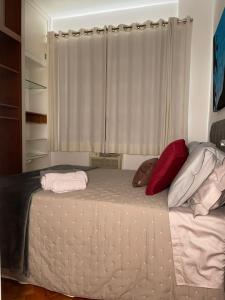 a bedroom with a bed with two pillows and a window at Copa_chic in Rio de Janeiro