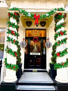 uma porta da frente de um edifício com decorações de Natal em Jubilee Hotel Victoria em Londres