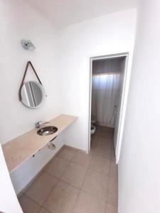 La salle de bains est pourvue d'un lavabo et d'un miroir mural. dans l'établissement Dúplex con patio y parrilla en Terrazas del Sol, à Neuquén