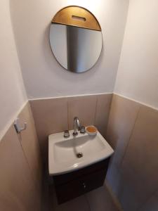 a bathroom with a sink and a mirror at Dúplex con patio y parrilla en Terrazas del Sol in Neuquén