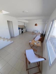 ein Wohnzimmer mit einem Tisch und Stühlen sowie eine Küche in der Unterkunft Dúplex con patio y parrilla en Terrazas del Sol in Neuquén