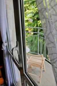 ein Fenster mit Blick auf einen Stuhl auf einem Balkon in der Unterkunft Il Posticino di Bellagio in Civenna