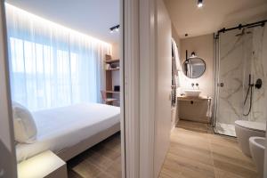 ein Badezimmer mit einem Bett, einer Dusche und einem Waschbecken in der Unterkunft Be Mate Torino Centro in Turin