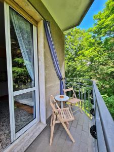 einen Balkon mit 2 Stühlen, einem Tisch und einem Fenster in der Unterkunft Il Posticino di Bellagio in Civenna